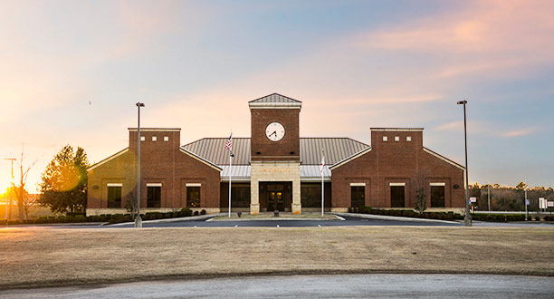A street-level view of the front entrance of Priceville's brick City Hall building.